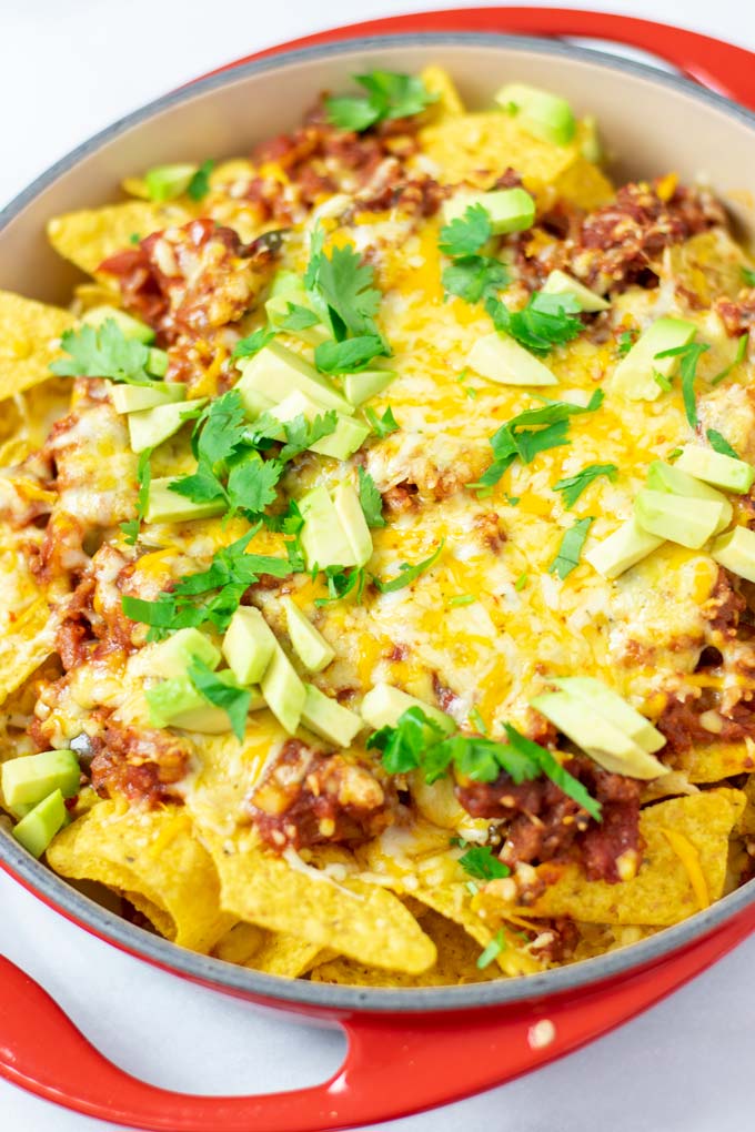 View of the baked Chilaquiles garnished with avocado cubes and cilantro.