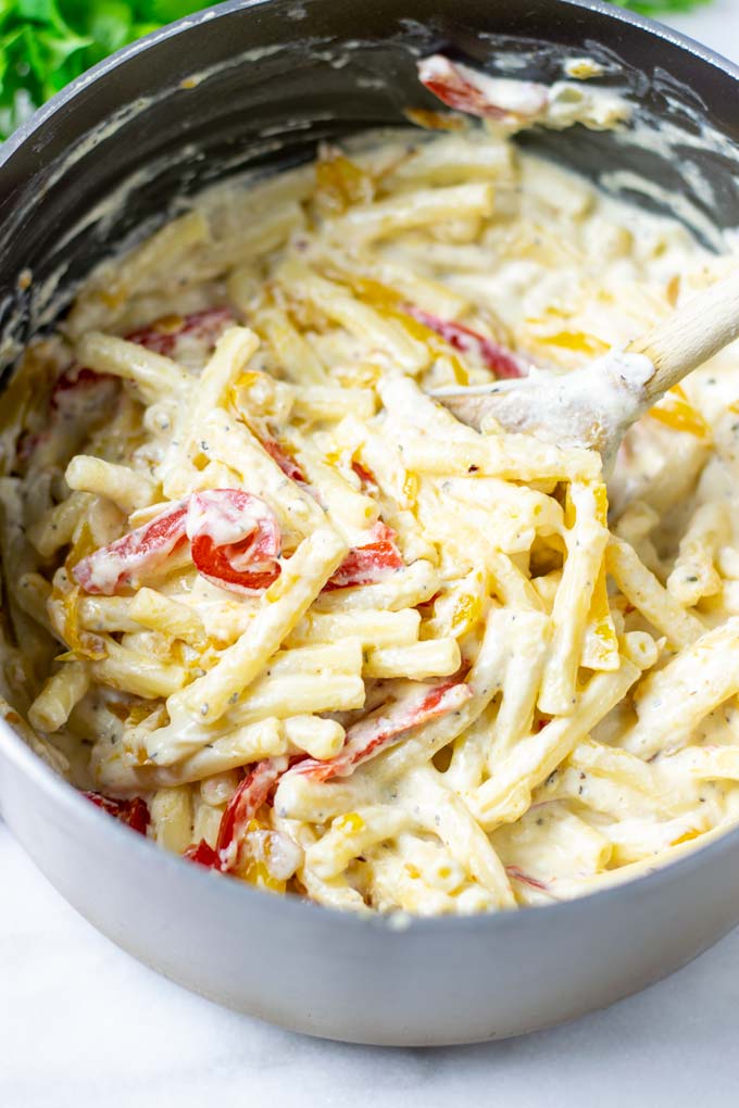 Creamy sauce of the Pasta Primavera as a portion is lifted from the sauce pan.