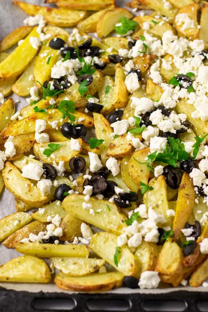 Closeup view of the baking sheet with the finished Greek Fries.