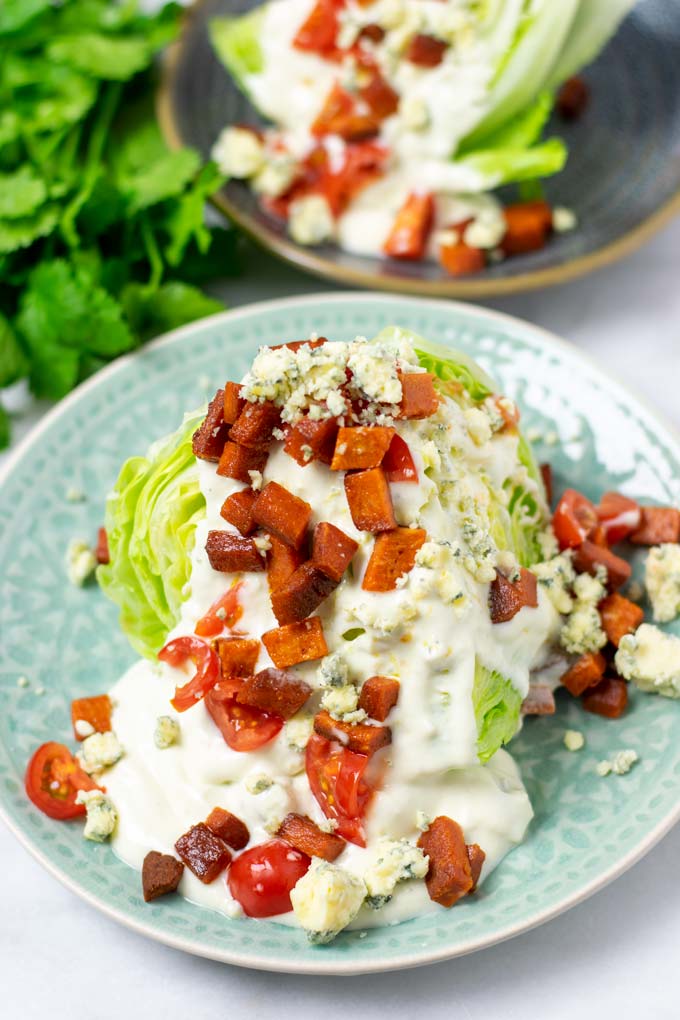 A portion of the Wedge Salad with a second one in the background.