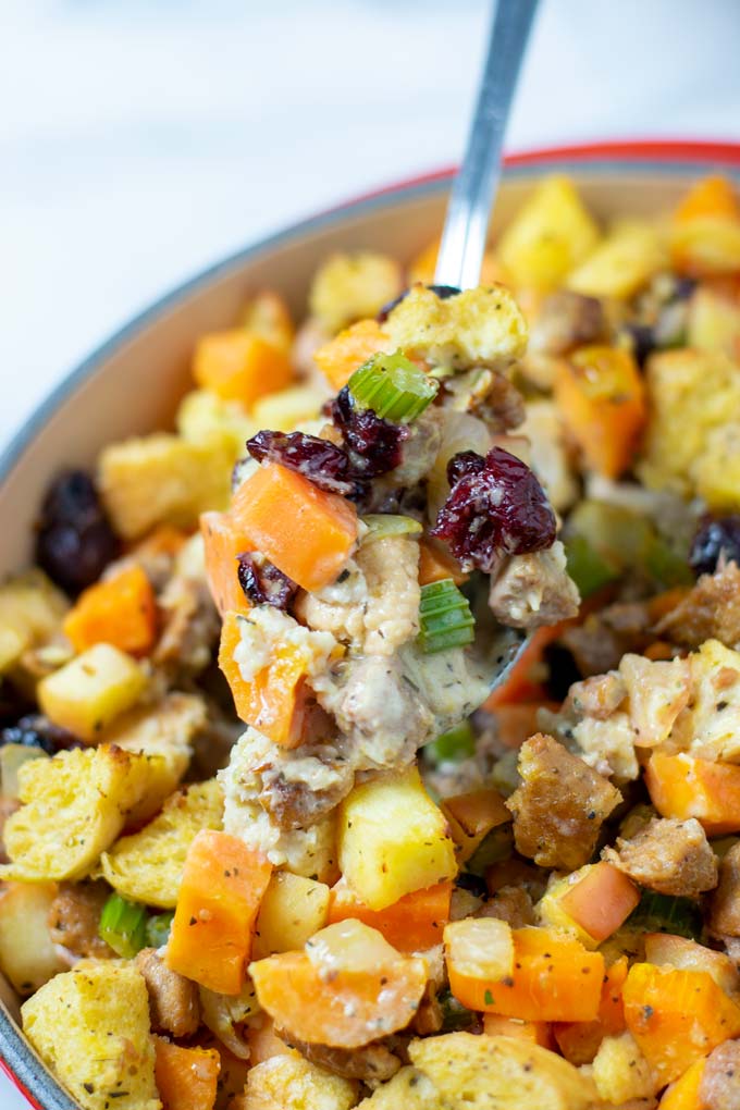 A large spoonful of of the Sweet Potato Stuffing is lifted from the casserole dish.