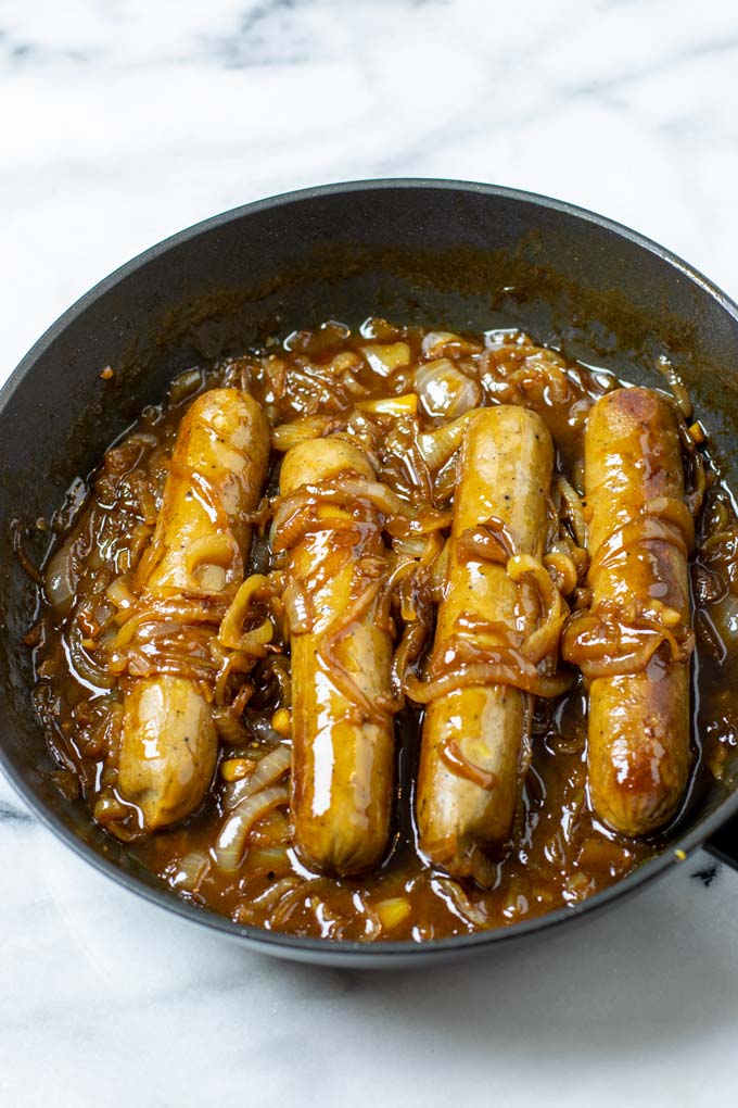 Closeup view of the vegan sausages in onion gravy.