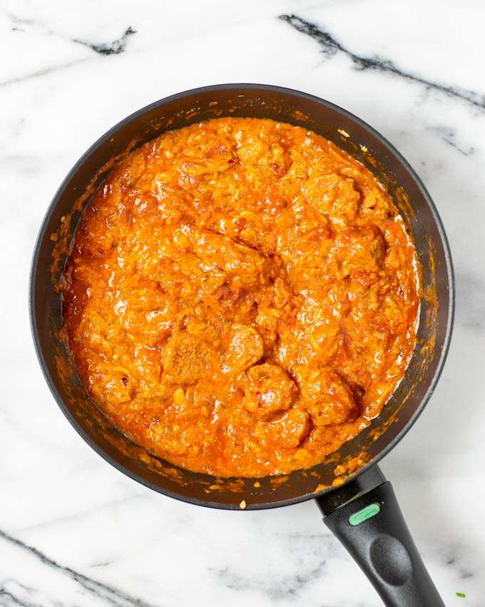 Top view on a pan with the mixed chorizo and tomato sauce.