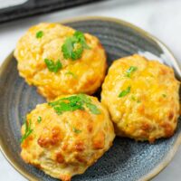 Three Cheddar Bay Biscuits on a blue plate.