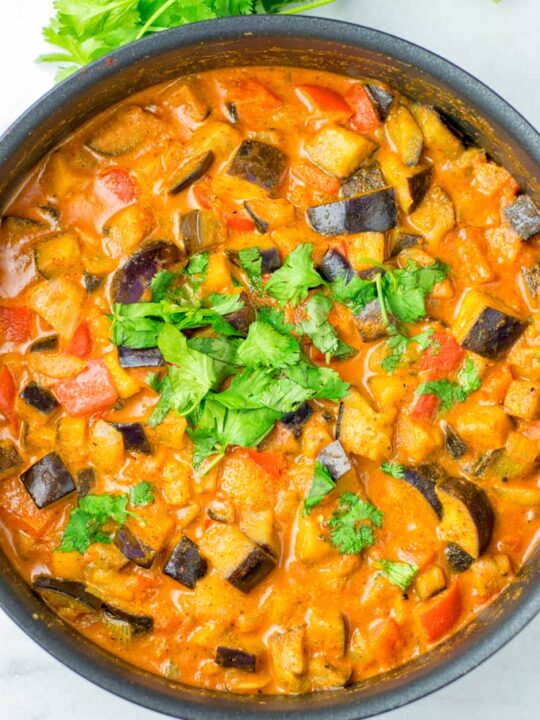 Top view of a large cooking pan with the Eggplant Curry, topped with fresh cilantro.