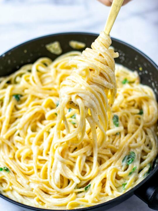 Lemon Pasta rolled on a golden fork, lifted out of the pan.