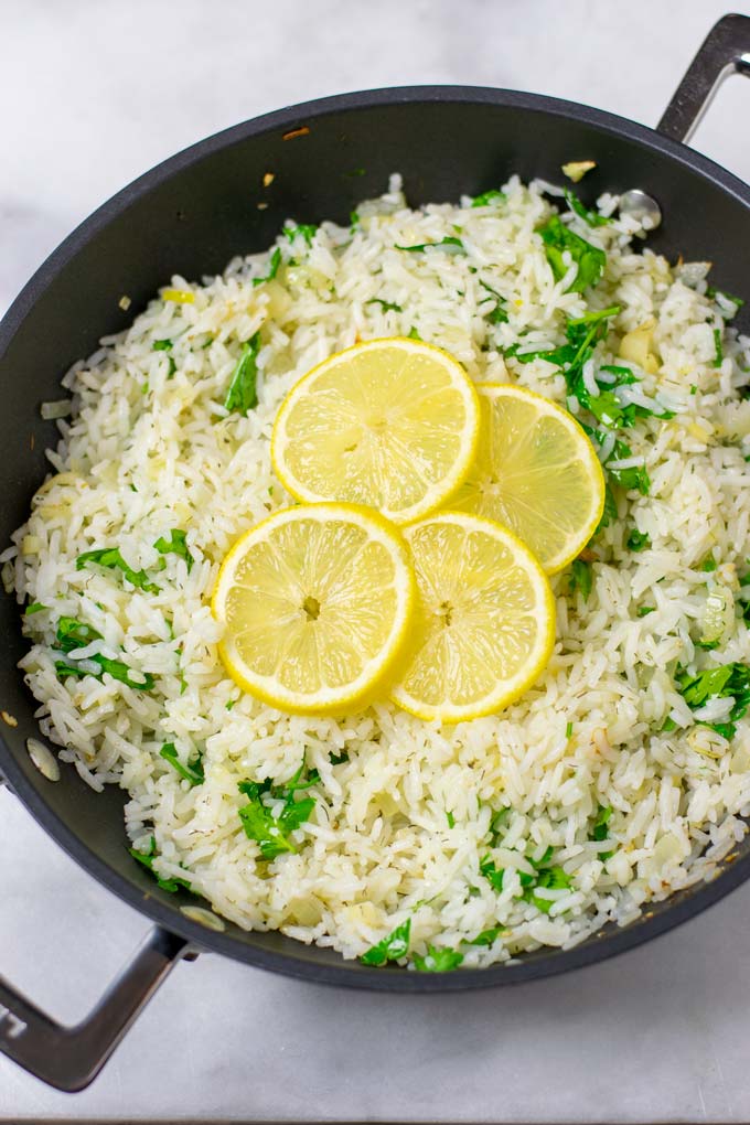Four thin slices of lemon are used to garnish the Lemon Rice in the pan.