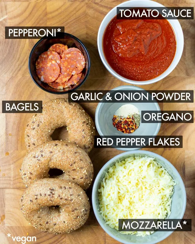 Ingredients needed to make the easy Pizza bagels are collected on a wooden board.