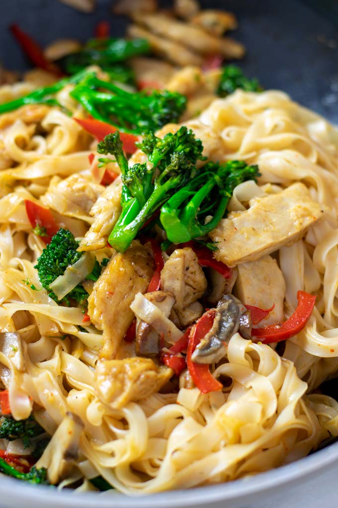 Closeup of the Rice Noodles in a pan showing the broccoli, mushrooms, bell pepper, and vegan chicken bites.