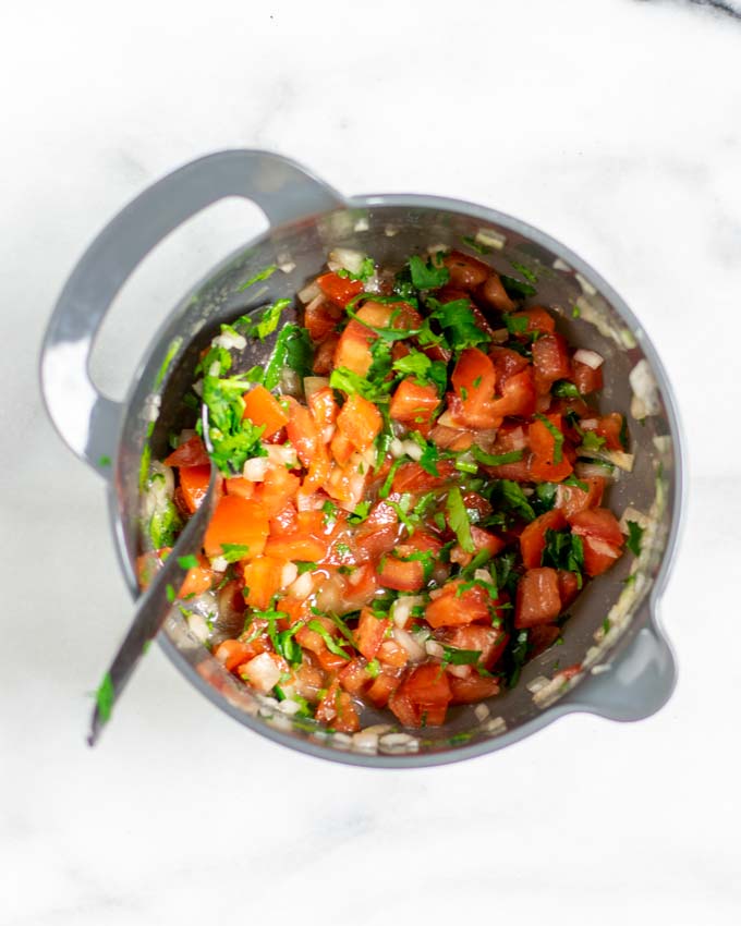 Top view on a small mixing bowl with tomato topping.