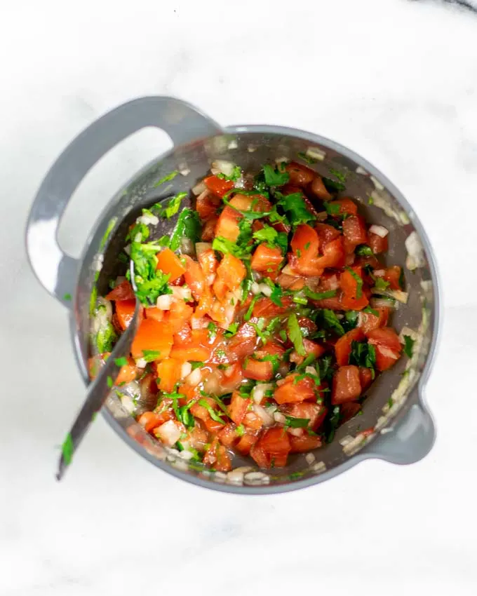 Top view on a small mixing bowl with tomato topping.