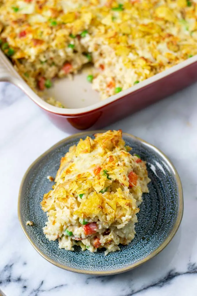 A portion of the Chicken and Rice Casserole on a small plate in front of the casserole dish.