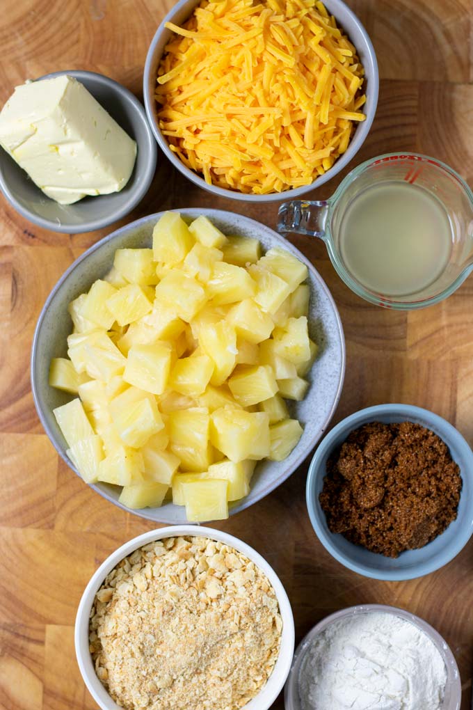 Ingredients for the Pineapple Casserole are assembled on a wooden board.