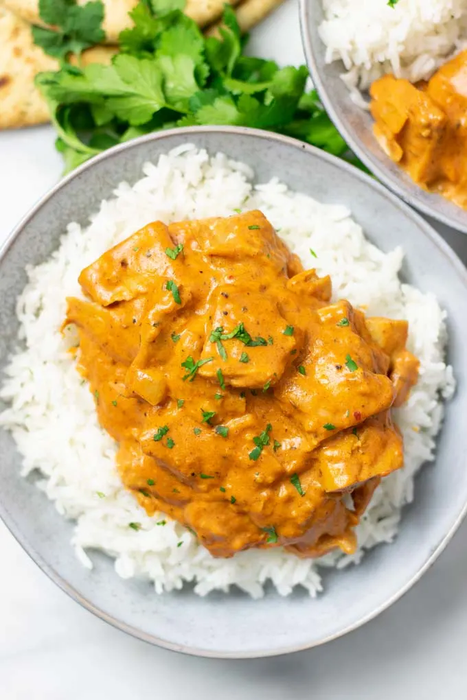 Top view on a plate with Butter Chicken over Basmati rice.