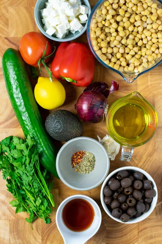 Ingredients for the Chickpea Salad are collected on a wooden board.
