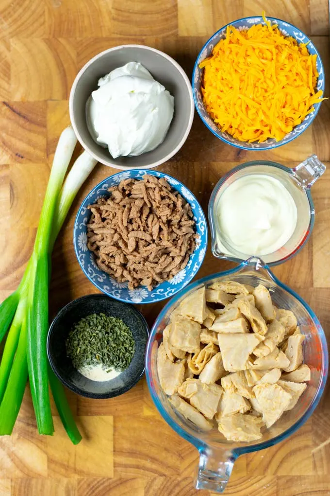 Ingredients needed to make the Crack Chicken are assembled on a wooden board.