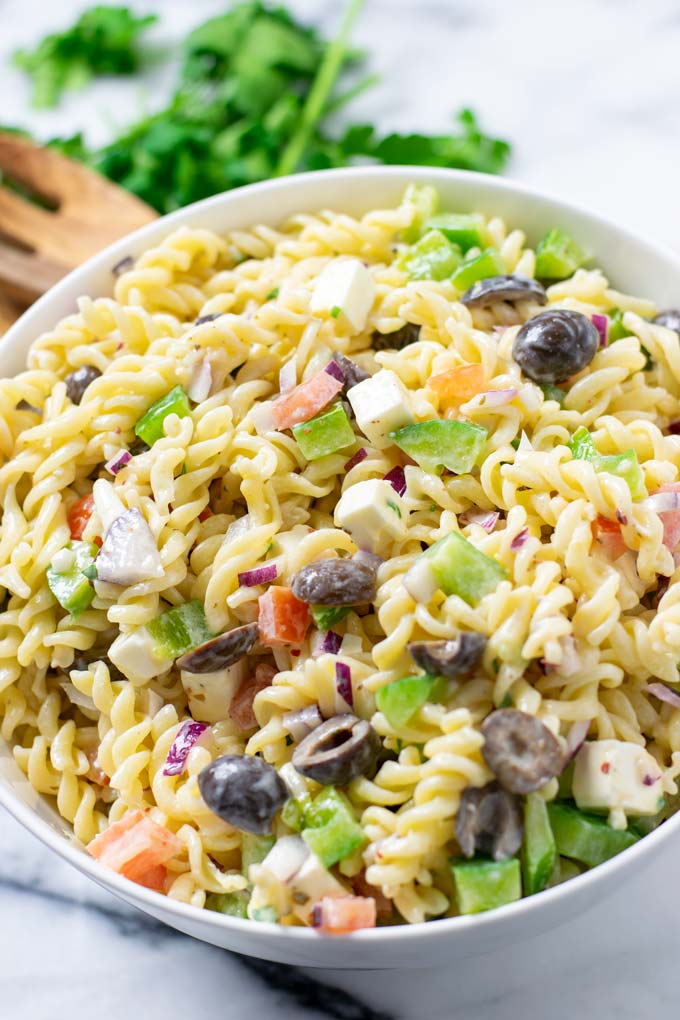 The ready pasta salad is in a white serving bowl.