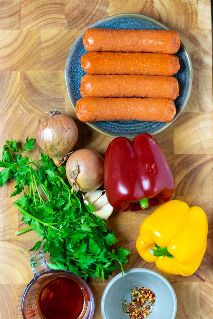 Ingredients for the Sausage and Peppers are assembled on a wooden board.