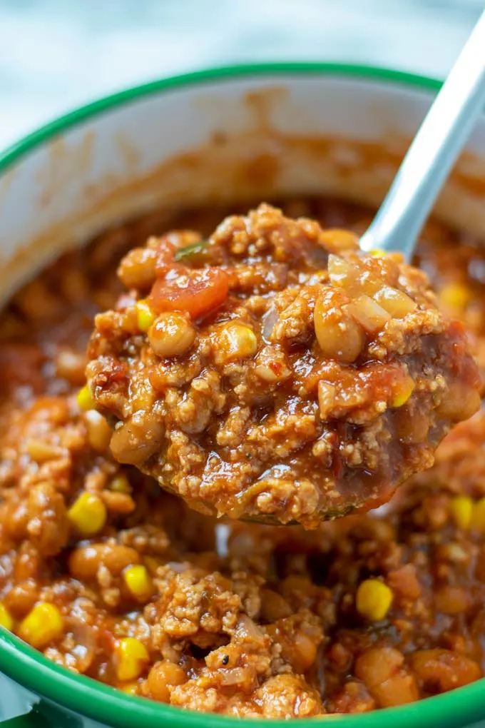 A large spoon lifts a big portion of the Taco Soup from the pot.