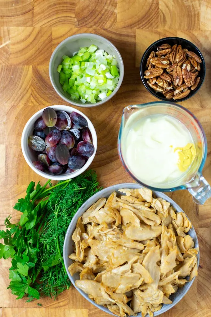 Ingredients needed to make the vegan Chicken Salad are assembled on a wooden board.