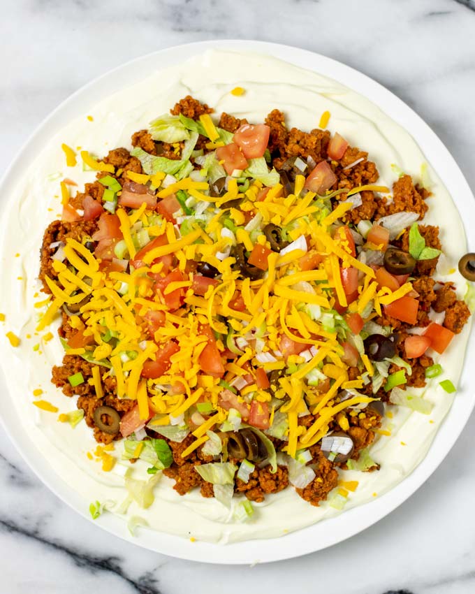 Top view of the Taco Dip topped with vegan cheddar cheese shreds.