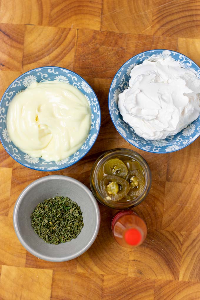 Ingredients for making the creamy Jalapeño sauce assembled on a wooden board.