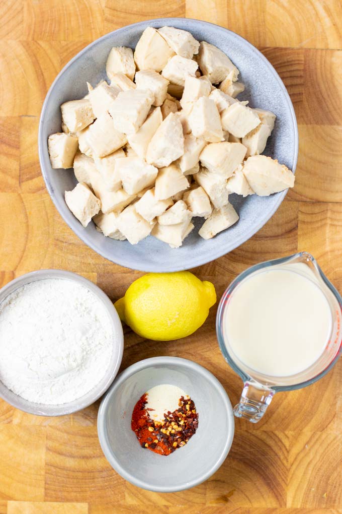 Ingredients needed to make the vegan Popcorn Chicken are assembled on a wooden board.