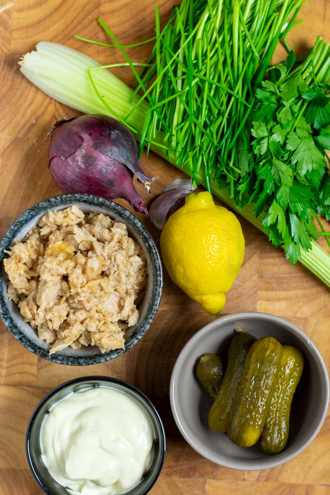 Ingredients needed to make the vegan Tuna Salad are assembled on a wooden board.