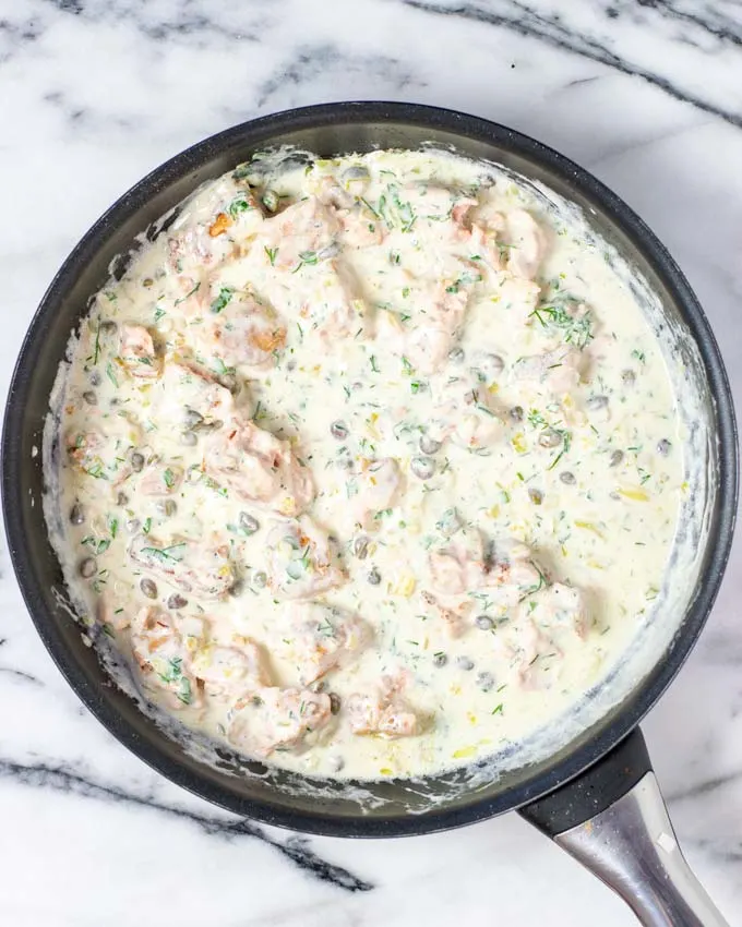 Top view on a saucepan with the creamy salmon sauce.