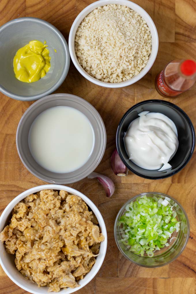 Ingredients needed to make Tuna Patties are collected before preparation on a wooden board.