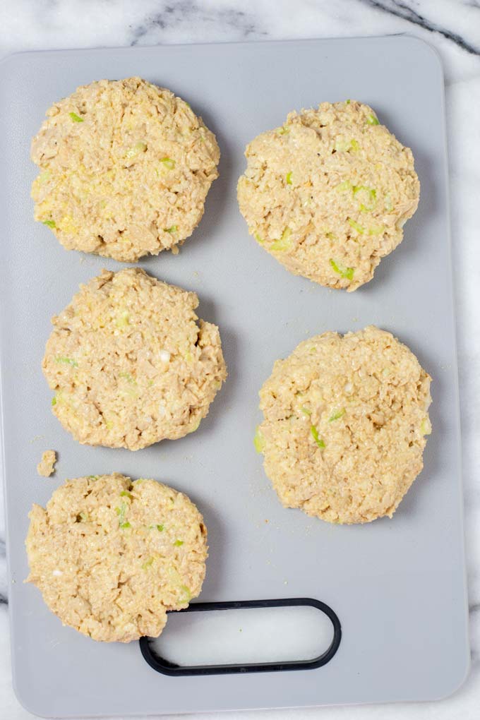 Five formed Tuna Patties on a board before frying.