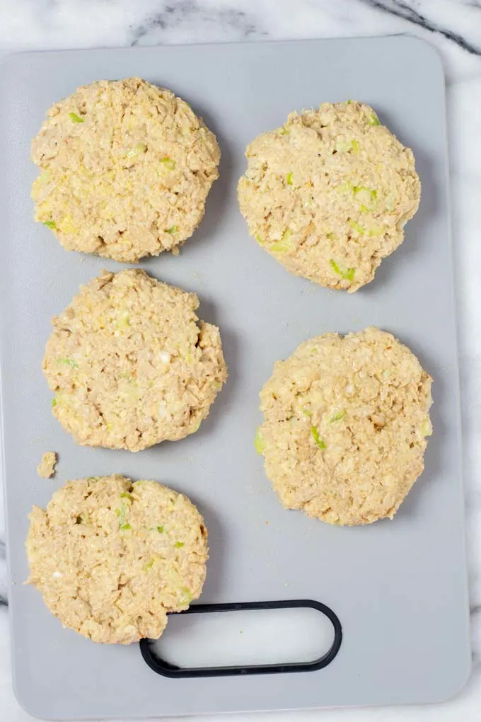 Five formed Tuna Patties on a board before frying.