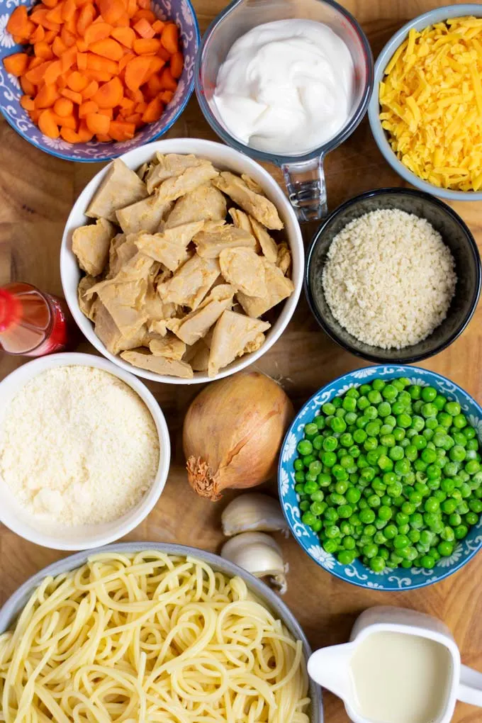 Ingredients needed for the Chicken Noodle Casserole are collected on a wooden board.