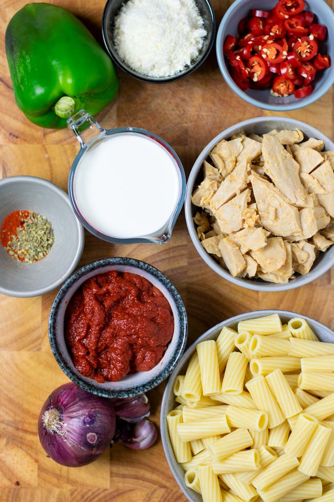 Ingredients needed to make Chicken Riggies are assembled on a wooden board.