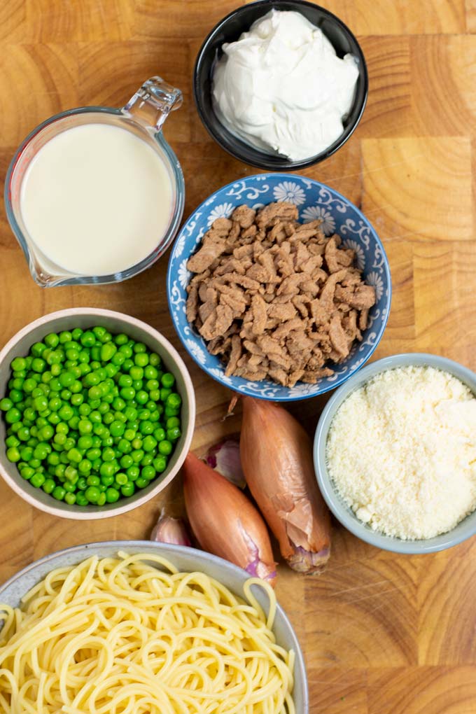 Ingredients needed for making the Pea Pasta are collected on a wooden board.