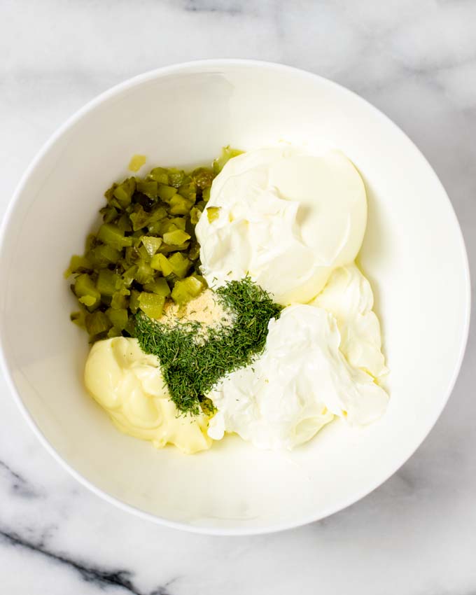 All ingredients for the Pickle Dip are transferred to a large mixing bowl.