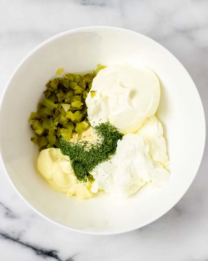 All ingredients for the Pickle Dip are transferred to a large mixing bowl.