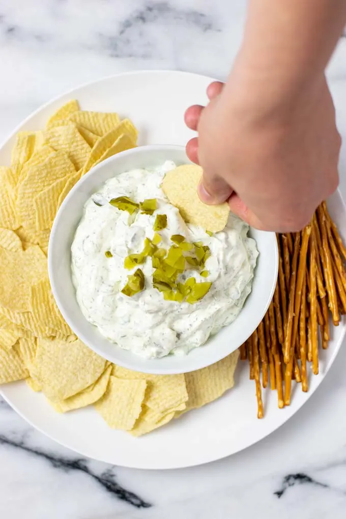 A potato chip is dipped into the Pickle Dip.