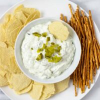 Top view of Pickle Dip served with potato chips and pretzels.