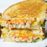 View of a stack of cut open Tuna Melt sandwiches.