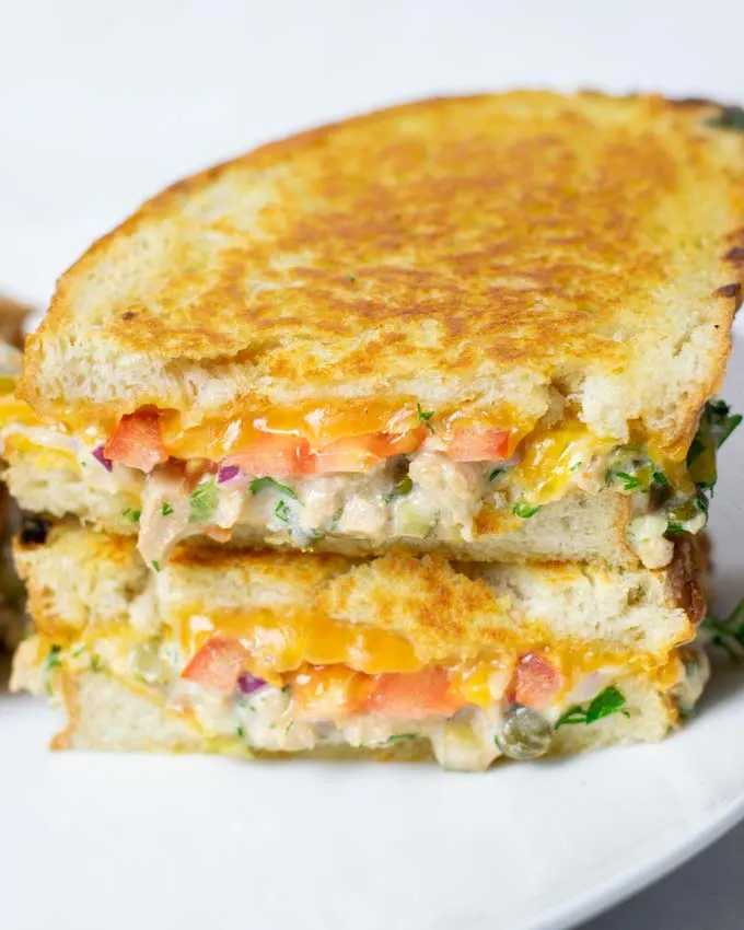 View of a stack of cut open Tuna Melt sandwiches.