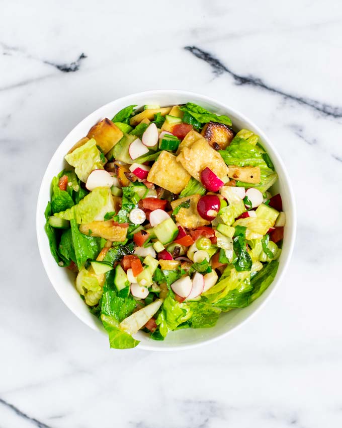 Top view of a white serving bowl with the Fattoush Salad.