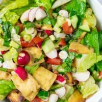 Closeup on the ready Fattoush Salad showing the fresh ingredients engulfed in Mediterranean dressing.