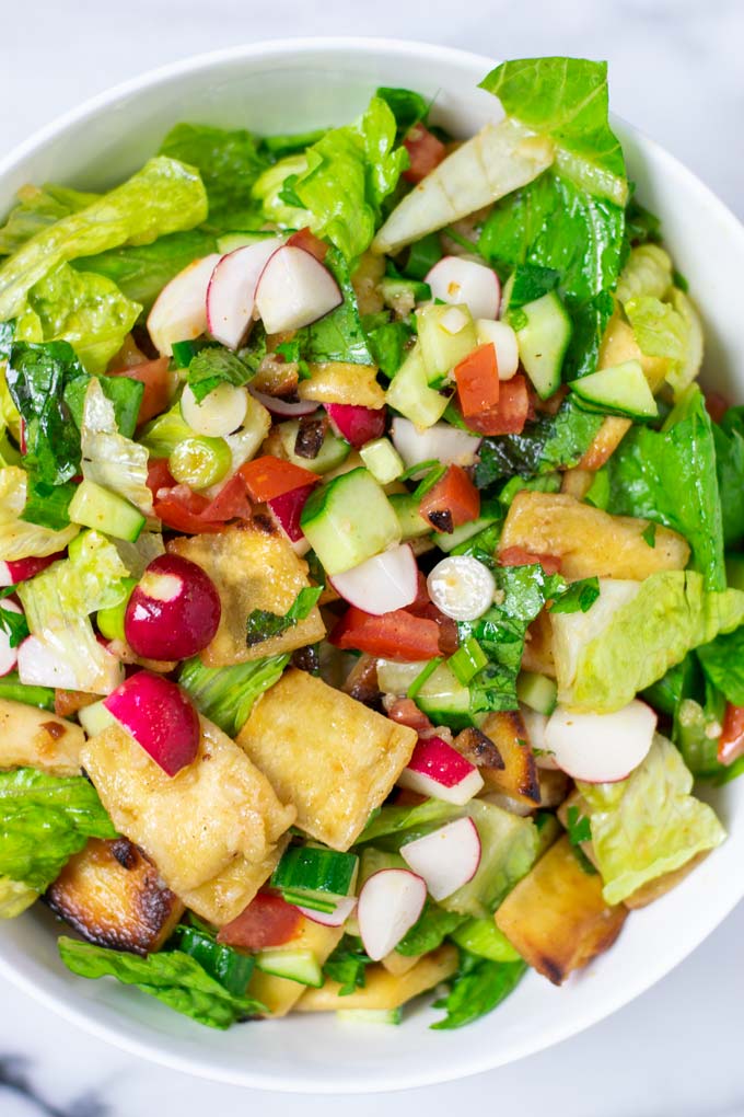 Closeup on the ready Fattoush Salad showing the fresh ingredients engulfed in Mediterranean dressing.