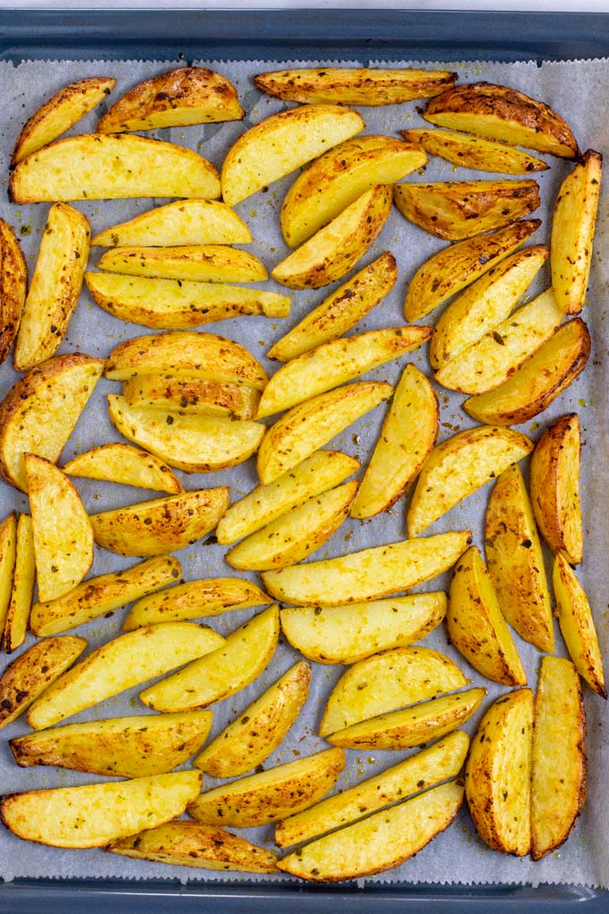 Top view on a baking sheet with the baked Potato Wedges.