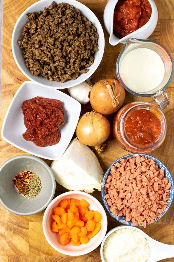 Ingredients needed for making Ragu Sauce are collected on a wooden board.