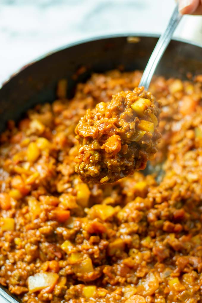 View of a big spoon of Rage Sauce being lifted from the pan.