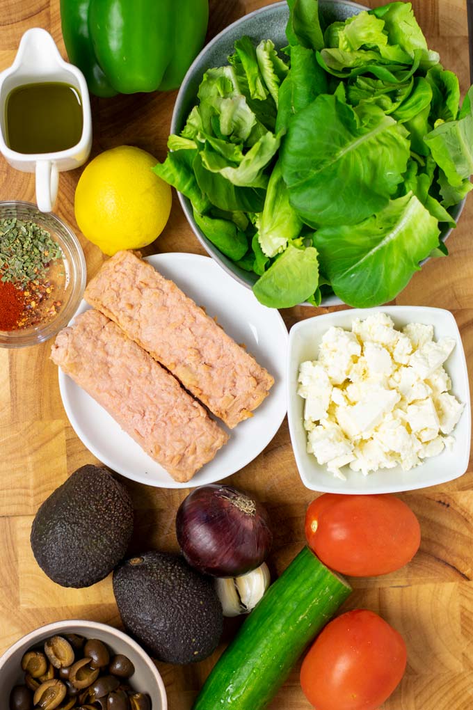 Ingredients needed to make Salmon Salad are assembled on a wooden board.