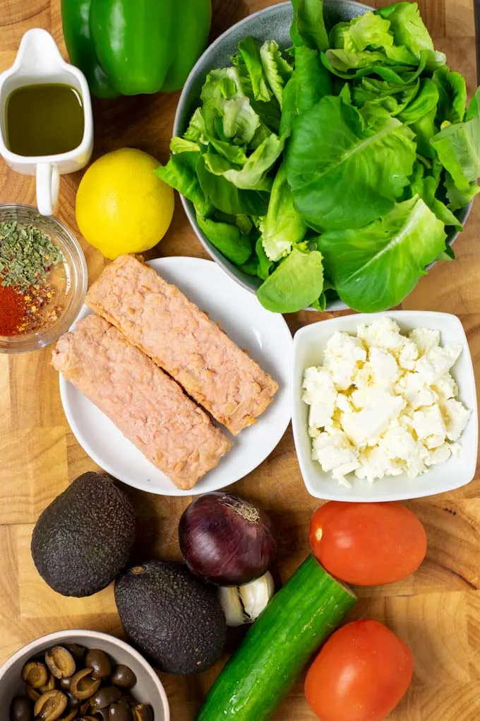 Ingredients needed to make Salmon Salad are assembled on a wooden board.