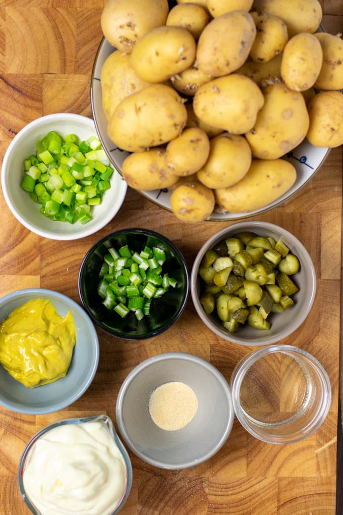 Ingredients for making the Southern Potato Salad are collected on a wooden board.